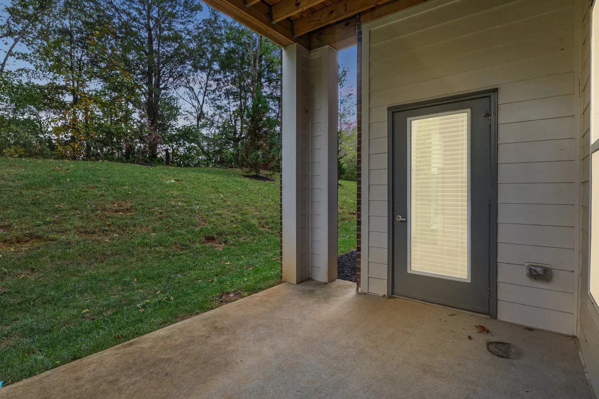 This image captures the inviting front entrance of the property, featuring a welcoming front door, lush green grass, and an appealing outdoor space. The scene suggests a tranquil yet accessible environment that serves as a threshold between busy city life and home relaxation.