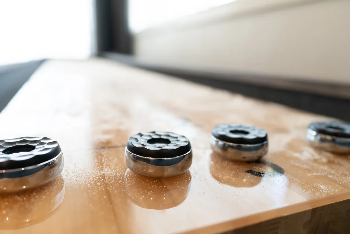 An interior shot highlighting metal weights on a smooth wooden surface, suggesting an area equipped for light fitness routines or active breaks within the home.